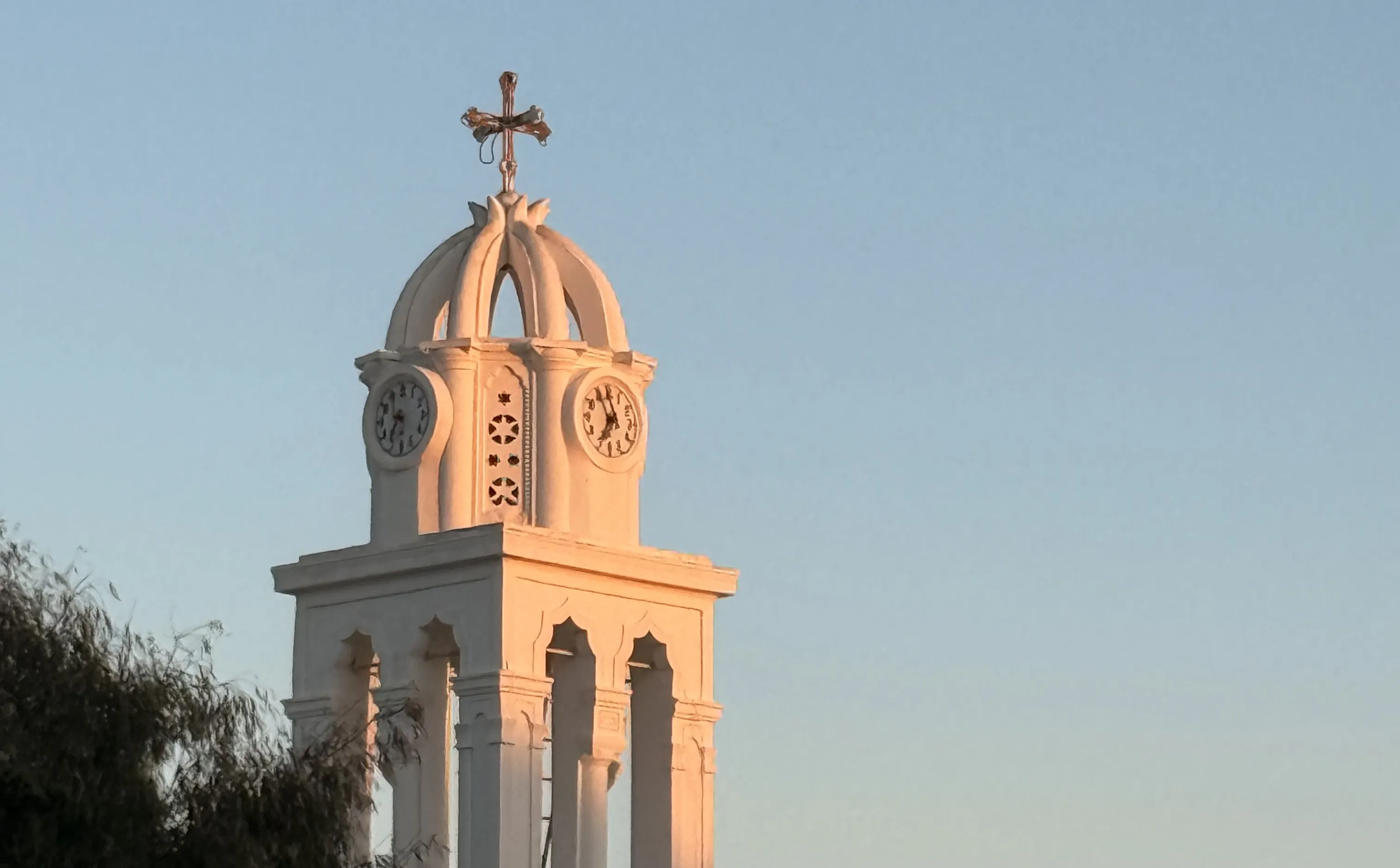 A whitewashed bell tower in evening light